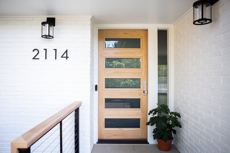 A Ranch house front door with made of natural wood with five rectangular glass panels